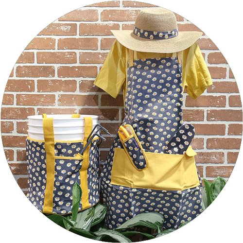 A set of dark blue and yellow gardening gear with daisy print, including a bucket bag, apron and sun hat.